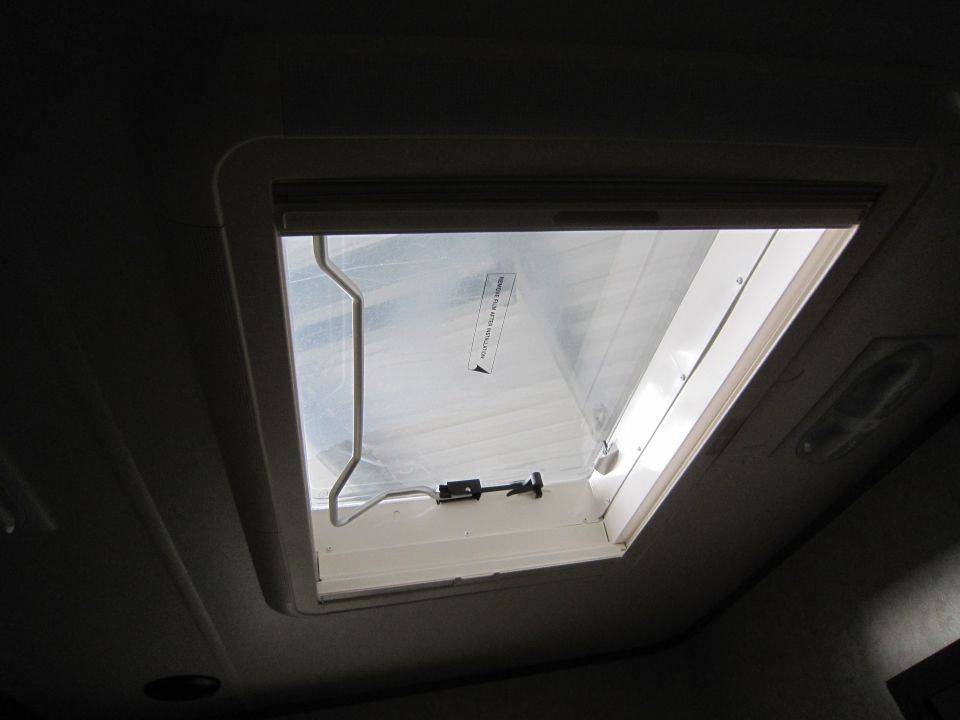 RV skylight with a closed shade and a latch