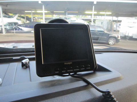 2008 Ford F-450 - A Voyager monitor is mounted on the dashboard of a vehicle, with boats and RVs visible in the background.