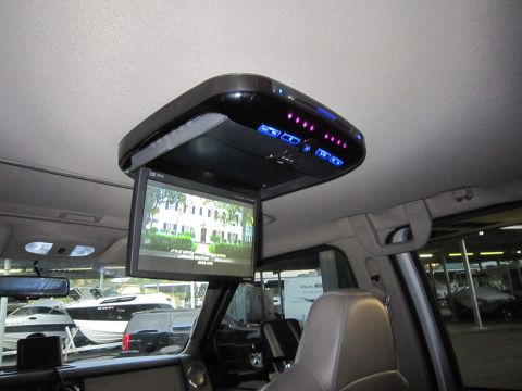 2008 Ford F-450 - The interior of a vehicle features an overhead entertainment system with a drop-down screen, showing a scene of a house.