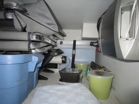 2008 Ford F-450 - The interior of a vehicle's cargo area is filled with various storage containers and folded seating components.