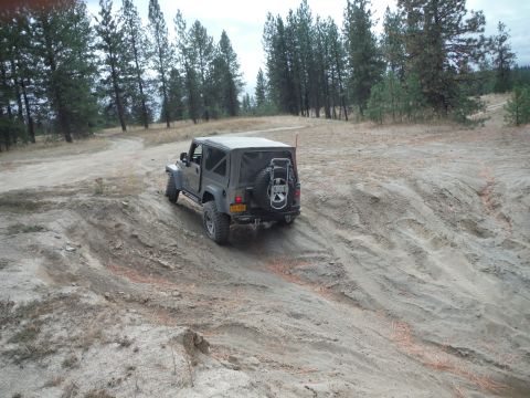 2005 Jeep Wrangler - A gray Jeep Wrangler navigates a sandy off-road trail.