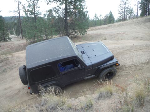 2005 Jeep Wrangler - Black 2005 Jeep Wrangler TJ with hardtop navigating a sandy, wooded off-road trail.