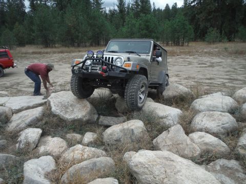 2005 Jeep Wrangler - A 2005 Jeep Wrangler navigates a rocky obstacle course, with another vehicle visible behind.