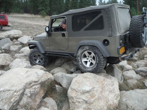 2005 Jeep Wrangler - A Jeep Wrangler TJ navigates a rocky trail, with another vehicle visible in the background.