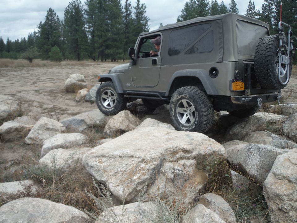Gray 2005 Jeep Wrangler TJ driving over rocks