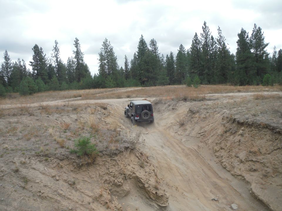 Jeep Wrangler going down a dirt hill off-road. It's a JK generation model