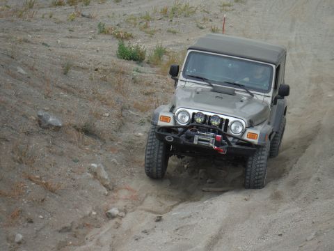 2005 Jeep Wrangler - A silver 2005 Jeep Wrangler navigates a dusty, off-road trail.