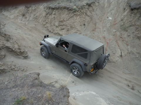 2005 Jeep Wrangler - A Jeep Wrangler navigates a steep, dusty off-road trail.