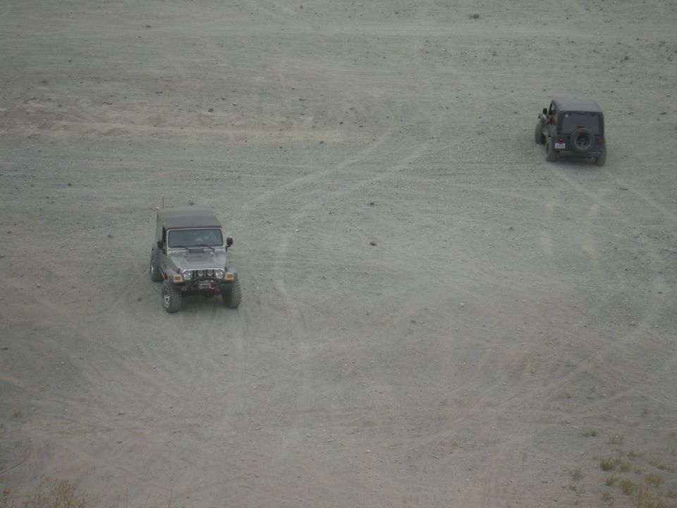 Two Jeep Wranglers on a dirt track, one in the foreground, one further back