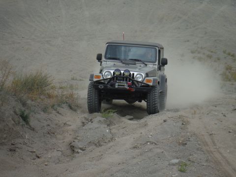 2005 Jeep Wrangler - A silver Jeep Wrangler navigates a dusty off-road trail.