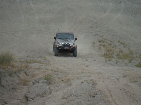 2005 Jeep Wrangler - Jeep Wrangler navigating off-road terrain on a dirt hill.