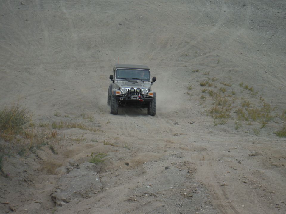 2005 Jeep Wrangler driving up a sandy hill, front view