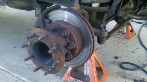 1997 Dodge 3500 - Front wheel hub and brake rotor assembly of a 1997 Dodge 3500, supported by jack stands for front-end work.