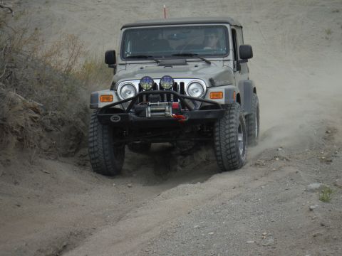 2005 Jeep Wrangler - Jeep Wrangler navigating an off-road trail with a winch and aftermarket bumper.