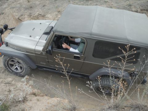 2005 Jeep Wrangler - A Jeep Wrangler Rubicon navigates an off-road trail with a driver at the wheel.