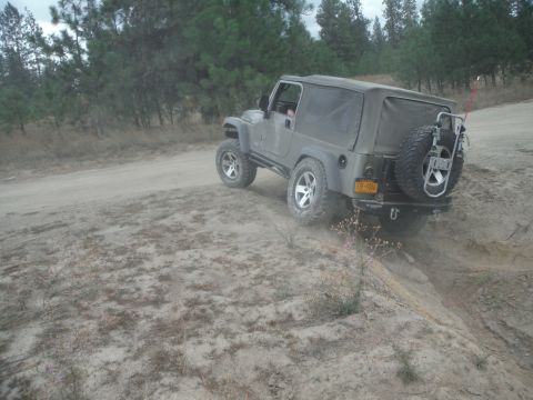 2005 Jeep Wrangler - A gray 2005 Jeep Wrangler navigates a dusty off-road trail.