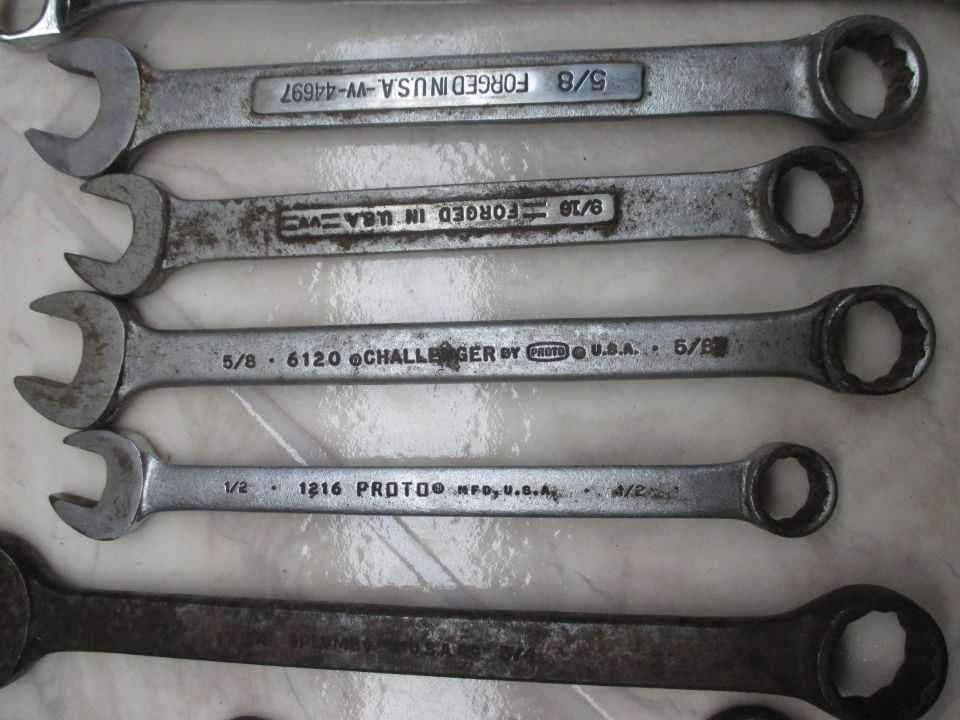Several wrenches are laid out, some with visible markings like 'FORGED IN U.S.A.' and sizes