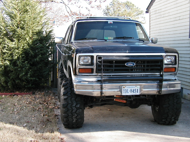 Front view of a dark 1980s Ford Bronco with Ford grille, light bar and Virginia plate YDL-8451