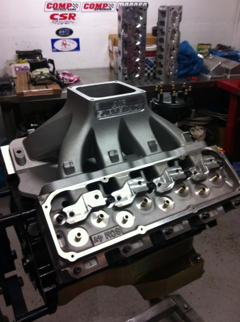 1972 Ford Ranchero - Close-up of engine parts, including an intake manifold and cylinder heads, in a workshop setting.