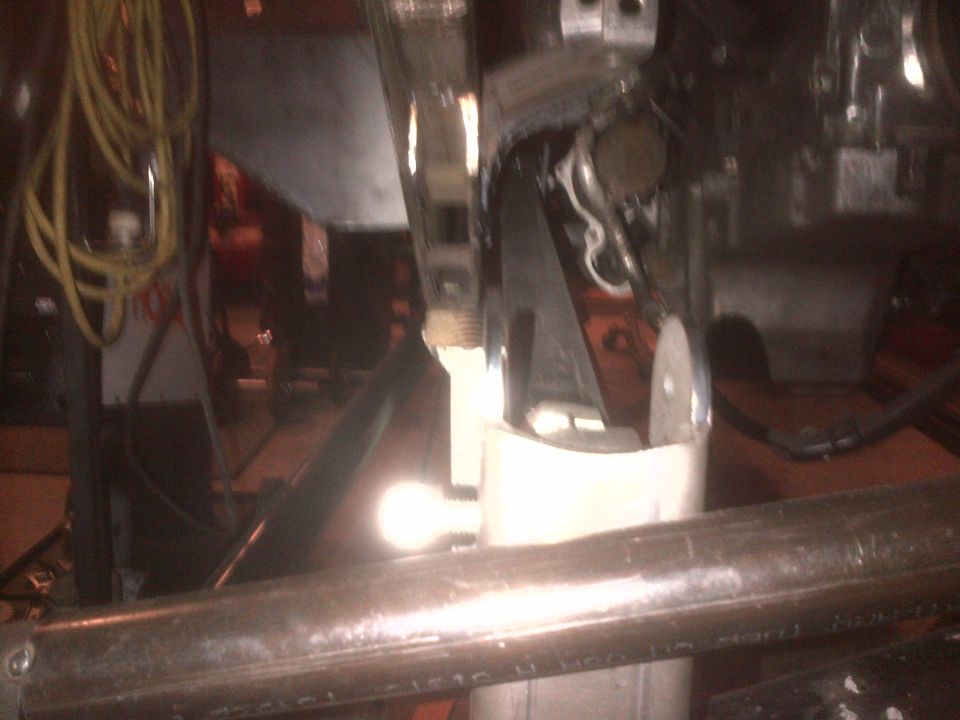 Undercarriage of a vehicle with exposed metal parts and wiring. A Supermotors logo is visible