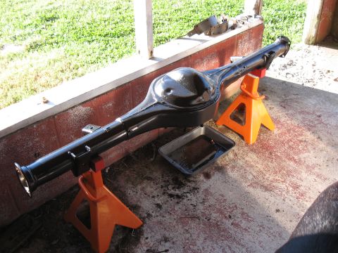 1994 Ford Bronco - A freshly painted rear axle assembly rests on jack stands, ready for installation.