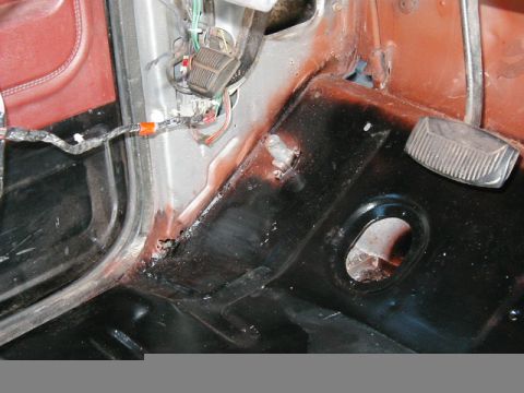 1985 Ford Bronco - Close-up view of the interior bodywork, showing pedals, wiring, and some rust.