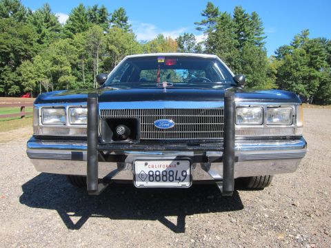 1991 Ford LTD Crown Victoria - Head-on view of a black Ford's chrome grille and front push bar, with a California license plate reading 888849 below the bumper.