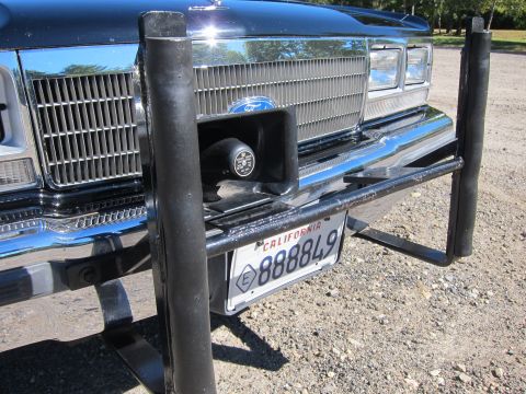 1991 Ford LTD Crown Victoria - Front grille of a black car fitted with a round siren speaker and a California license plate '888849', framed by a black push bar.