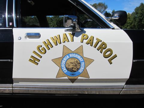 1991 Ford LTD Crown Victoria - Close-up of a patrol car's white front door reading HIGHWAY PATROL above the gold California Highway Patrol seven-point star.