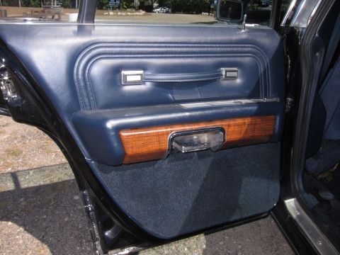 1991 Ford LTD Crown Victoria - Blue vinyl rear door panel with woodgrain accent, chrome handle and carpeted lower section, door open over pavers.