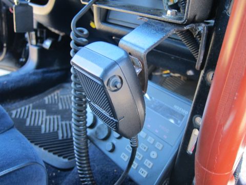 1991 Ford LTD Crown Victoria - handheld microphone clipped to a bracket mounted above a vehicle two-way radio control head labeled MR5180 in a car footwell.