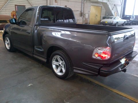 2003 Ford F-150 - Rear view of a dark gray 2003 Ford F-150 Lightning pickup truck parked indoors.