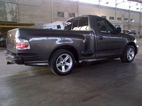 2003 Ford F-150 - 2003 Ford F-150 Lightning pickup truck seen from the rear three-quarter angle in an indoor setting.