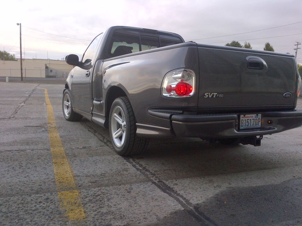 Dark gray Ford F-150 SVT Lightning pickup truck parked in a lot, rear view