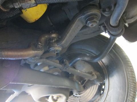 1991 Ford LTD Crown Victoria - Undercarriage view showing the front sway bar, tie rod end, and steering linkage next to a tire.