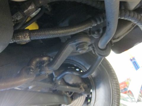 1991 Ford LTD Crown Victoria - Underside of a vehicle showing sway bar links, suspension components, and the inner edge of a tire.