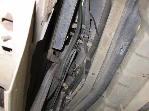 1991 Ford LTD Crown Victoria - Underside of a vehicle showing a frame rail, wiring harness, and a green-striped cable routed through the chassis.