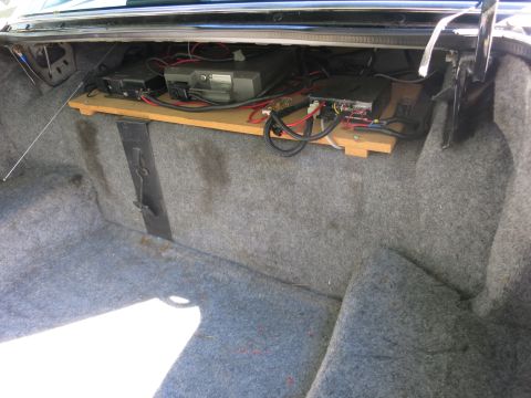 1991 Ford LTD Crown Victoria - Open car trunk showing modules, wiring, and connectors mounted on a wooden shelf along the rear panel.