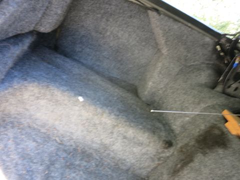 1991 Ford LTD Crown Victoria - Gray carpeted car trunk interior with a thin antenna wire stretched across the floor.