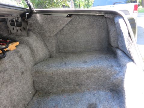1991 Ford LTD Crown Victoria - Gray carpeted car trunk interior viewed from the rear, with a white pickup truck visible in the background.
