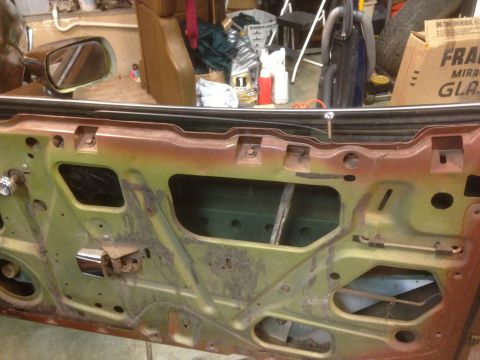 1972 Ford Ranchero - The internal structure of a car door is visible, with rust and exposed mechanical components.