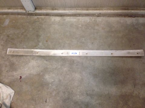 1972 Ford Ranchero - A Ford branded trim piece lies on a concrete floor.