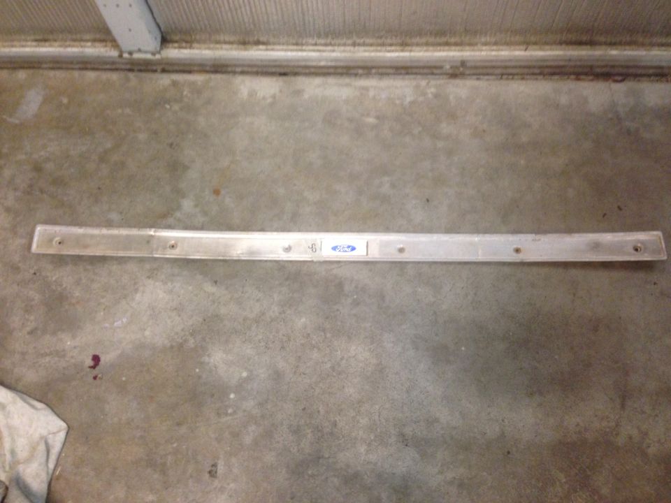 Metal trim piece with Ford logo and some numbers