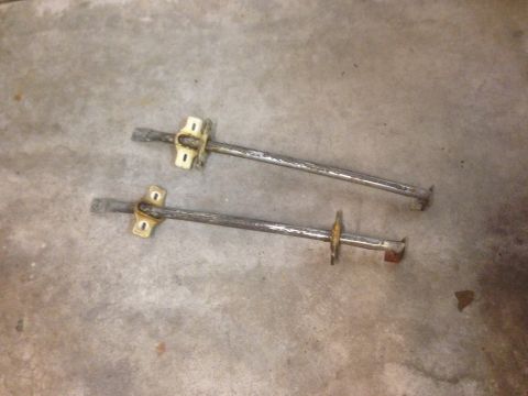 1972 Ford Ranchero - Two metal rods with mounting brackets are shown on a concrete floor. The registry claims these are from a 1972 Ford Ranchero interior, but…