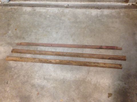 1972 Ford Ranchero - Three metal trim pieces are laid out on a concrete floor.