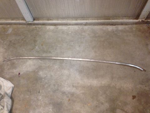 1972 Ford Ranchero - A single piece of chrome trim lies on a concrete surface, possibly a garage floor.