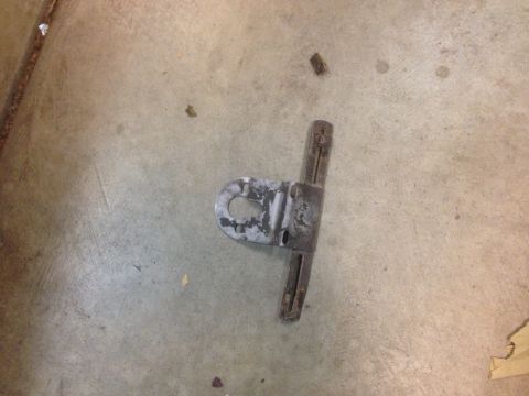 1972 Ford Ranchero - A metal bracket lies on a concrete floor, possibly a car part.