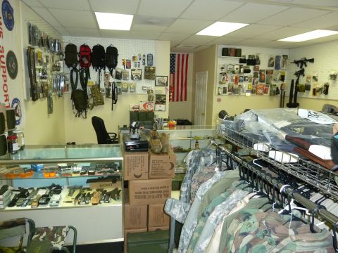 1992 Ford Mustang - A store interior displays camouflage clothing, tactical gear, and various items on shelves and in display cases.