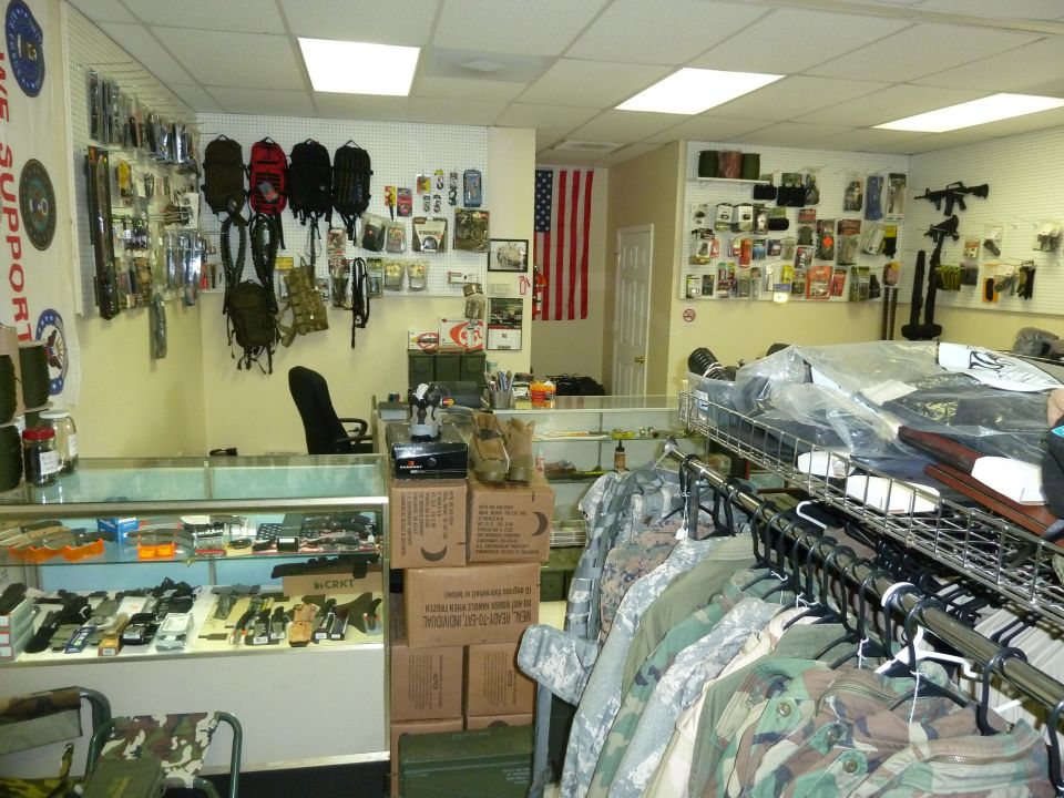 Interior of a store with military gear, clothing, and display cases filled with items