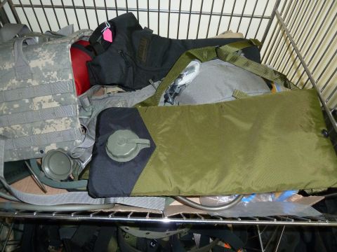 1992 Ford Mustang - Various pieces of military equipment, such as a hydration pack and a tactical vest, are stored on a metal shelf.